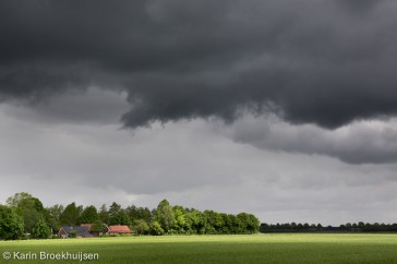 Cumulus en stratocumulus wolken drijven over het platteland van Drenthe