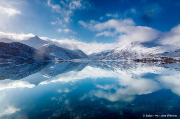De perfecte weerspiegeling van blauwe lucht en witte bergen creeeren een oneindige wereld. Lofoten, Noorwegen.