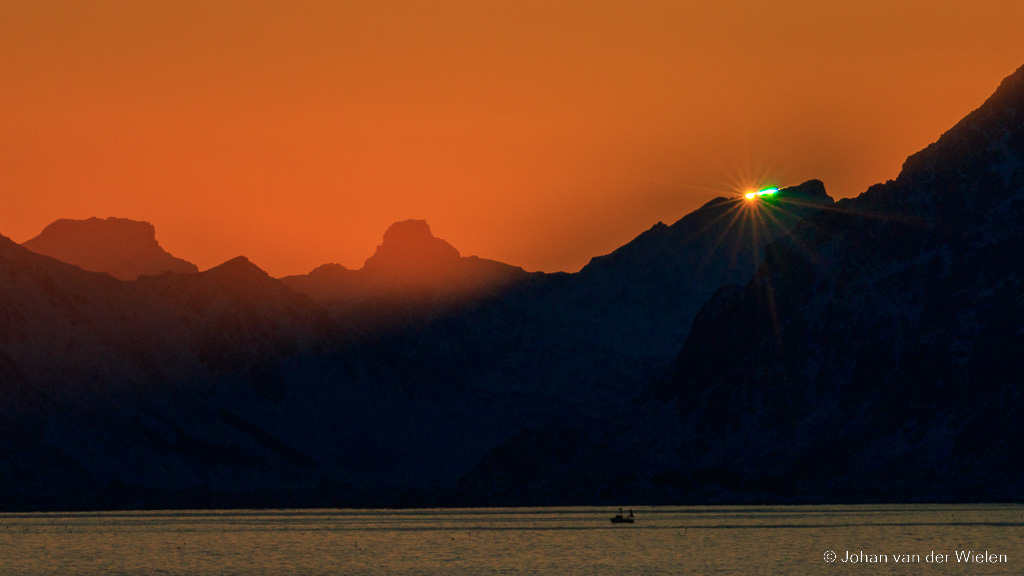 Bij scherpe oppervlakken, zoals bergranden, kan het licht ook op speciale manier breken en een groene flits laten zien. Dit is de winter op Lofoten.