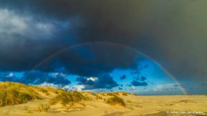 Een regenboog op het strand van Schiermonnikoog.